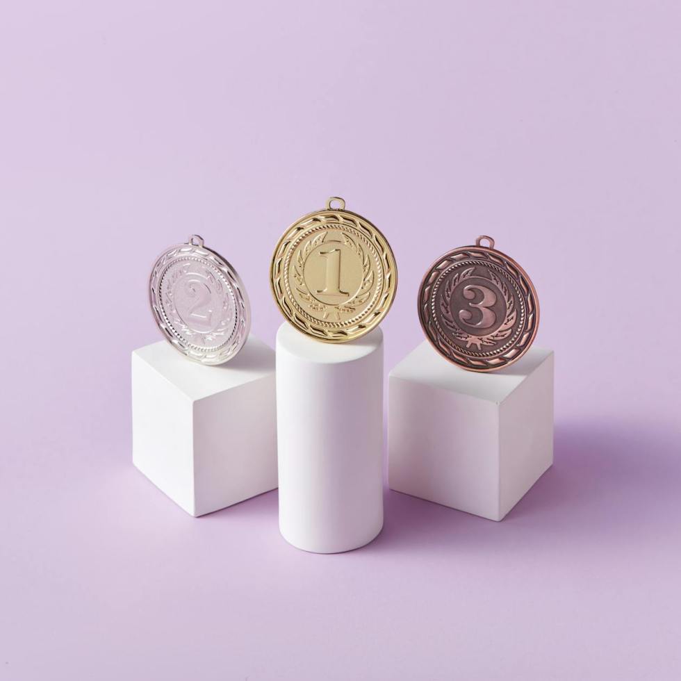 medals on pedestals on pink studio background