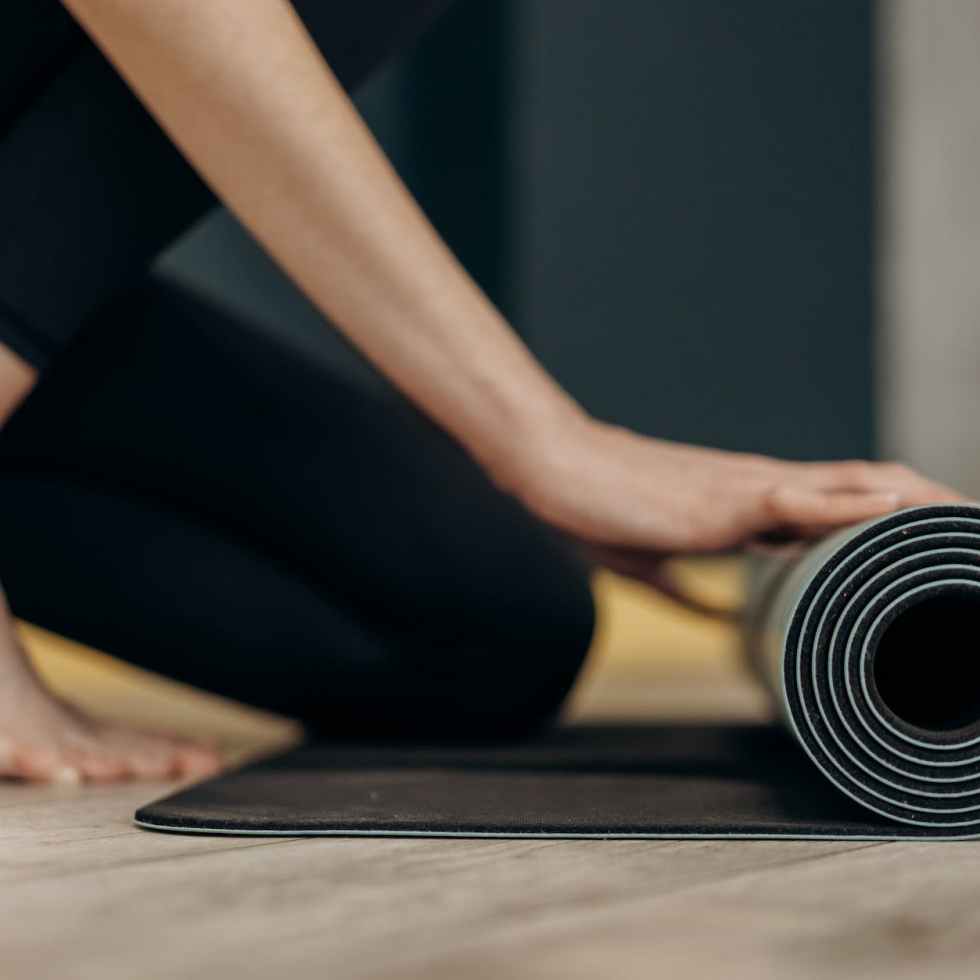 woman rolling a yoga mat