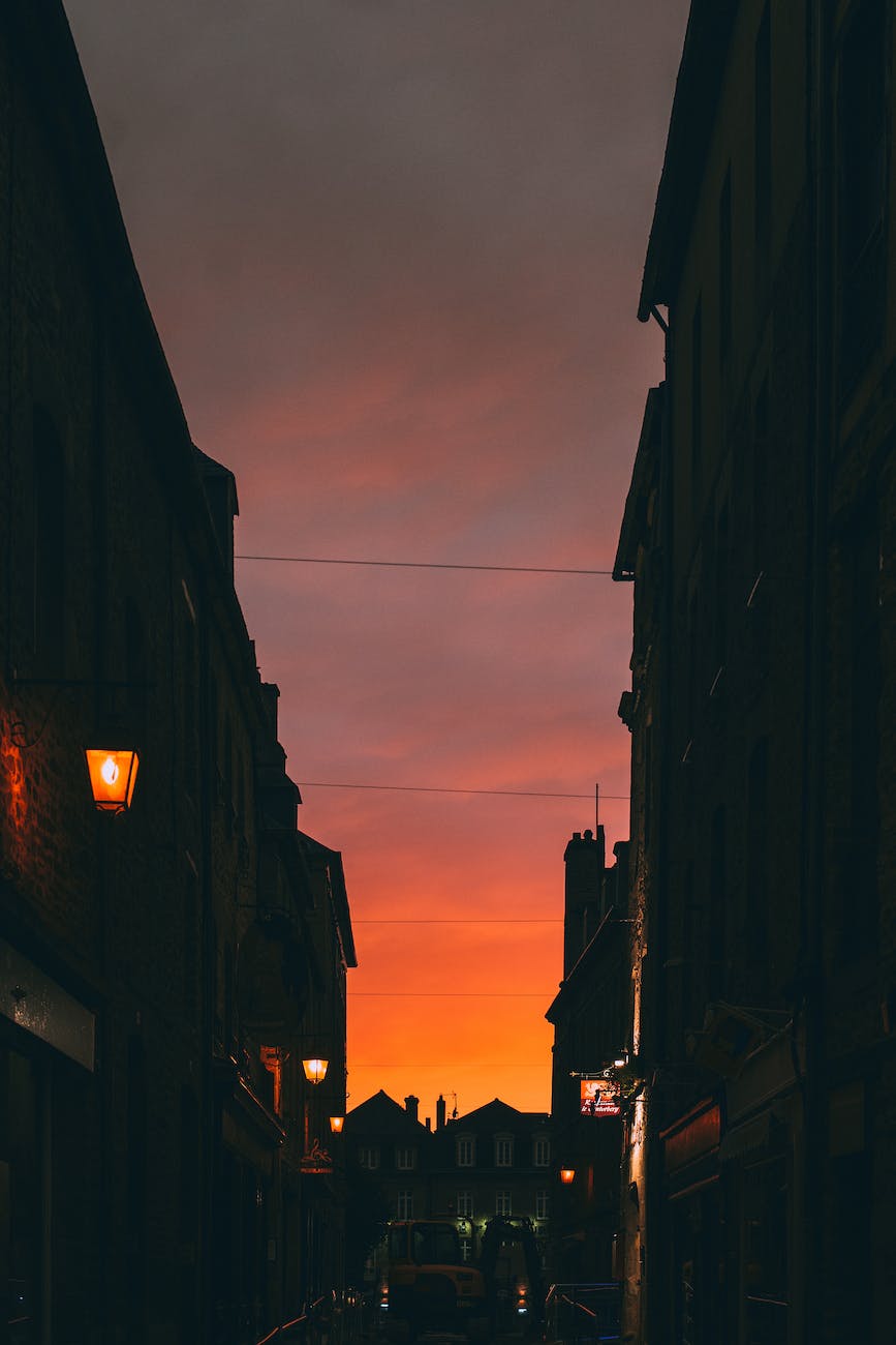 silhouettes of houses under bright red sunset sky