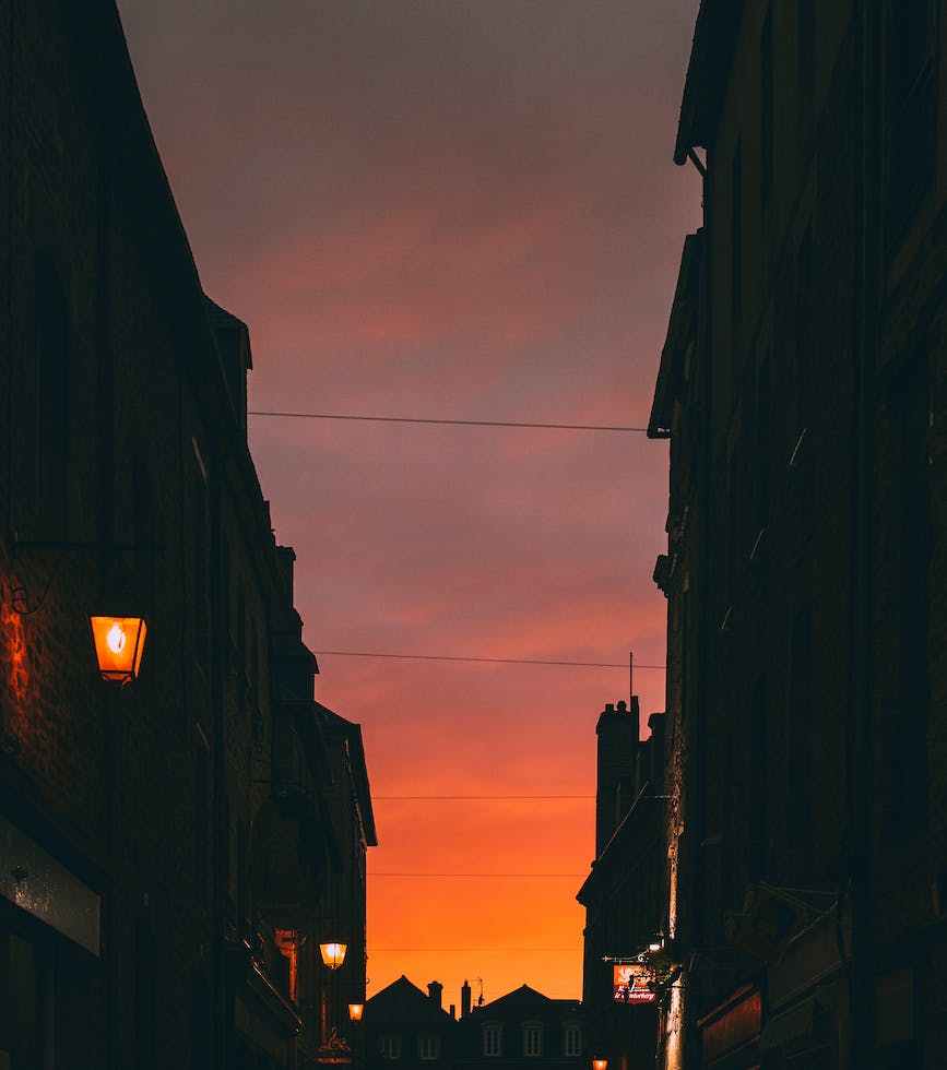 silhouettes of houses under bright red sunset sky