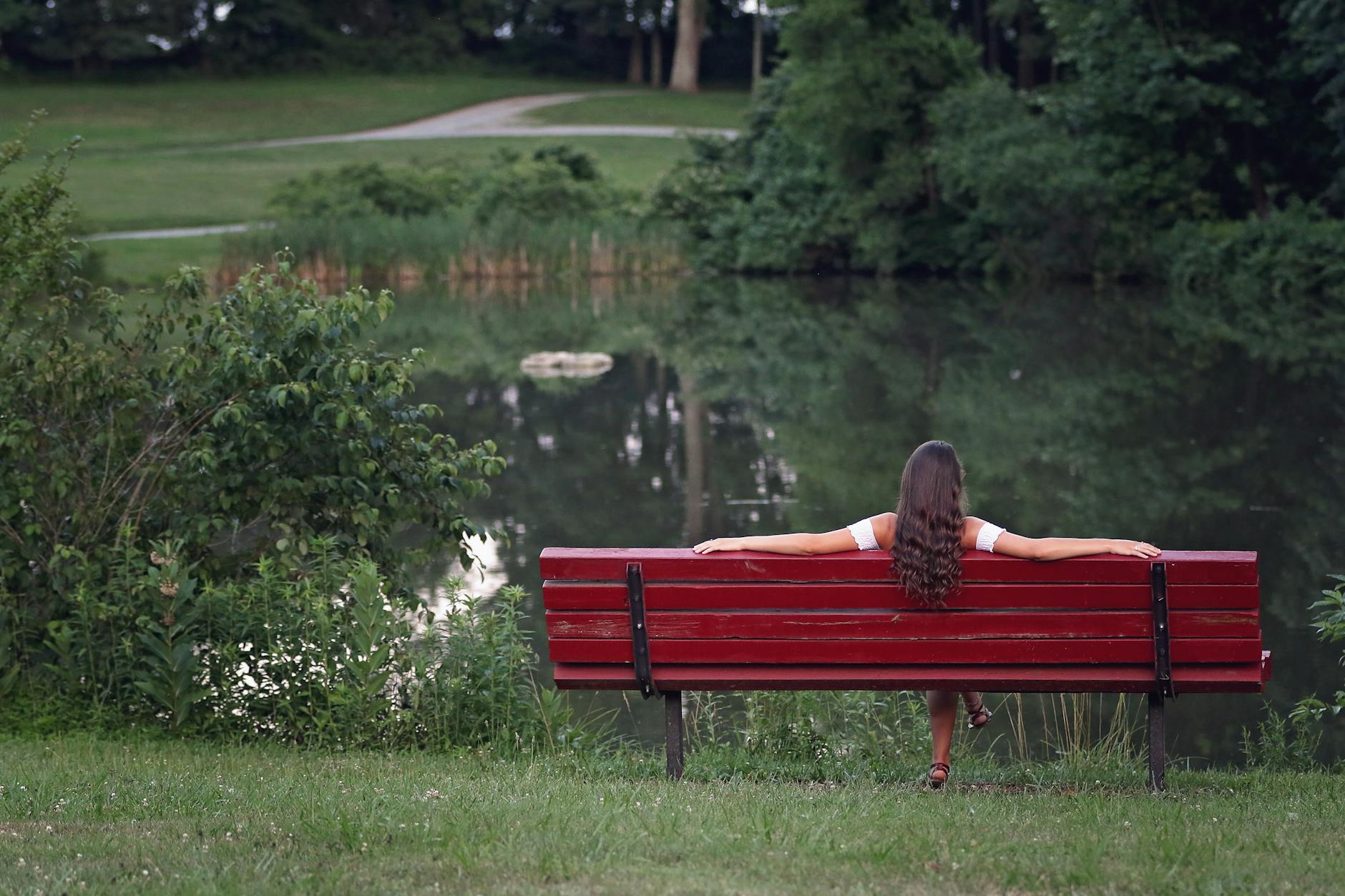 photography of woman relaxing on bench