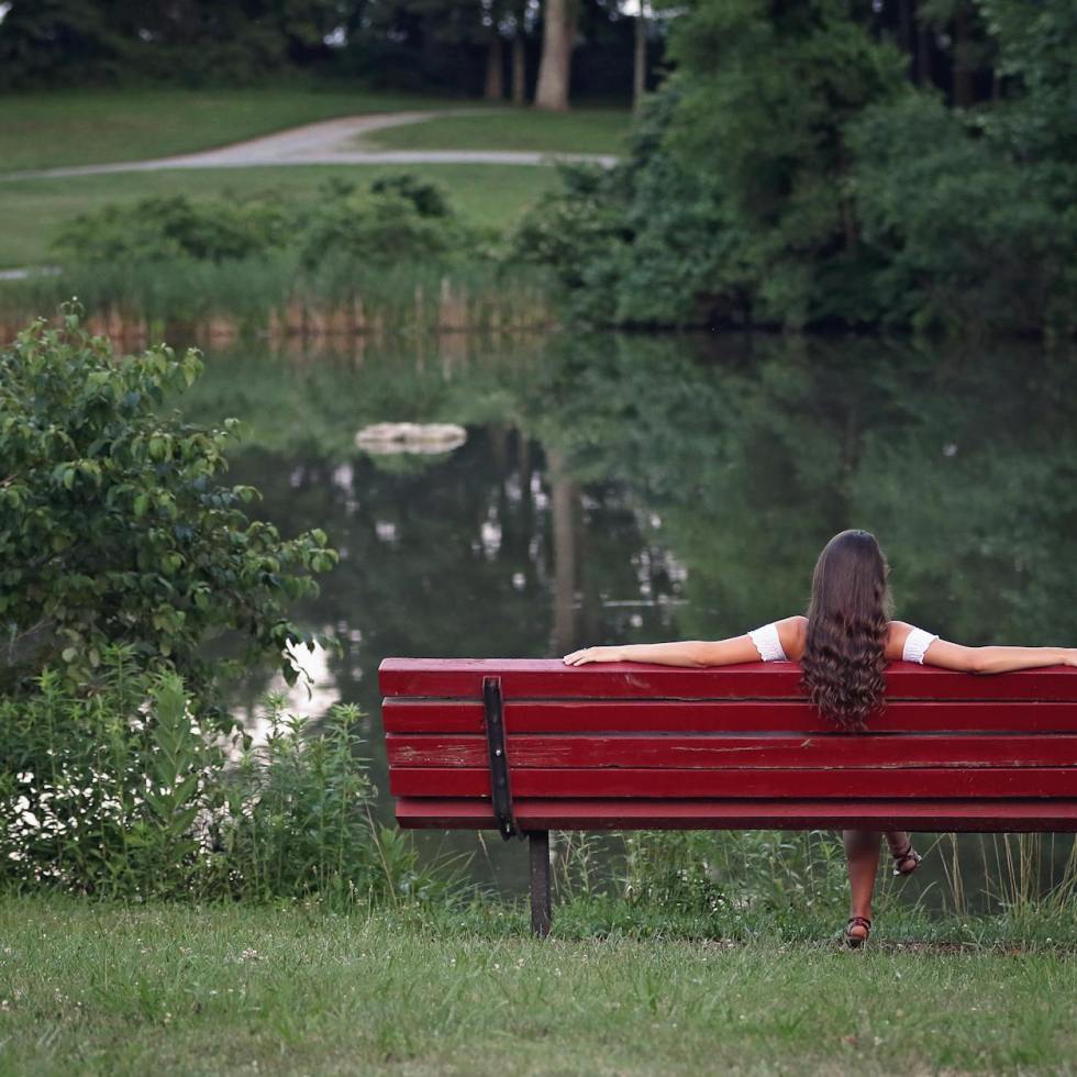 photography of woman relaxing on bench
